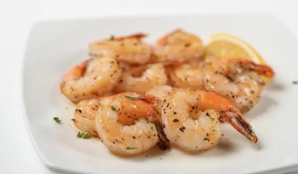 Plate of seasoned shrimp with a lemon wedge